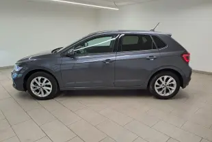 Volkswagen Polo 2023 gris cendré vue de profil côté gauche avec vitres arrière surteintées en intérieur showroom.