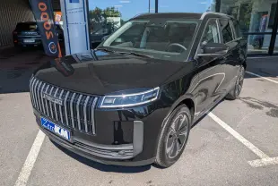 Vue 3/4 avant du JAECOO J5 noir carbone métal avec calandre verticale chromée et jantes design en concession.