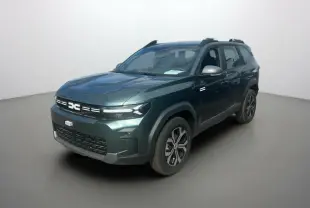 SUV Dacia Bigster vert cèdre en 3/4 avant droit avec barres de toit et jantes alu 17 pouces visibles.