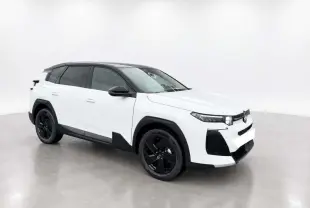 Vue 3/4 avant droit du Citroën C5 Aircross Hybrid blanc avec toit noir et jantes noires dans un studio lumineux.
