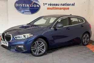 BMW Série 1 116i Business Design bleu vue 3/4 avant droit, avec jantes alliage et phares LED ellipsoïdaux.