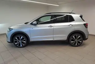Vue de profil côté gauche d'un Volkswagen T-Cross 2025 argent Reflet, version R-Line avec jantes noires et argentées.