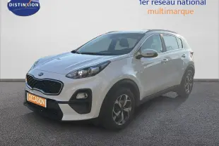 KIA Sportage blanc nacré métal en 3/4 avant droit, avec calandre noire et jantes bi-ton visibles.