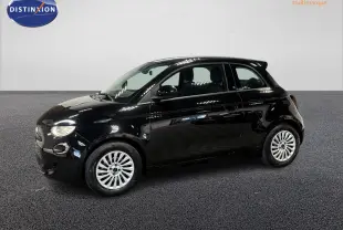 Profil droit de la Fiat 500 électrique noire 2024 avec jantes acier 15 pouces dans un showroom lumineux.