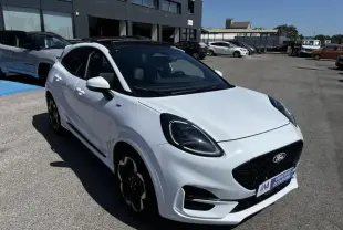 Ford Puma blanc 2025 en 3/4 avant droit, toit noir, calandre noire et jantes spécifiques ST-Line X visibles.
