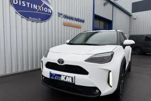 Vue 3/4 avant droite d'une Toyota Yaris Cross blanche pur avec feux LED et calandre noire sur parking extérieur.