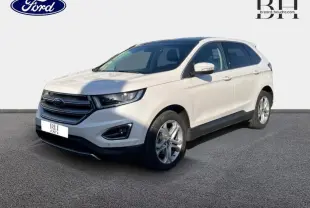 Vue 3/4 avant droit d'un Ford Edge blanc Platinum avec calandre chromée et jantes alliage sur fond clair.