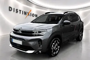 Citroën C5 Aircross gris platinium vue 3/4 avant droit, avec barres de toit et jantes alu distinctives.