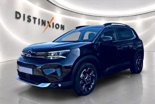 Citroën C5 Aircross noir vue 3/4 avant droit avec jantes alu et barres de toit en showroom lumineux.