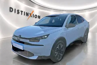 Citroën C4 X blanche vue 3/4 avant droit, avec jantes alu et phares LED dans un showroom lumineux.
