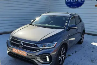 Volkswagen T-Roc gris Indium vue 3/4 avant droit, avec jantes alliage et badge R-Line visible.