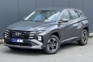 Hyundai Tucson 2026 Ecotronic Gray en 3/4 avant droit, avec jantes alliage et calandre noire distinctive.