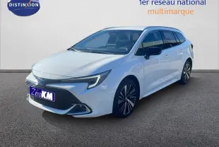 Toyota Corolla Touring Sport hybride blanc neige vue 3/4 avant droit avec jantes alliage et calandre noire distinctive