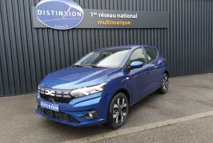Dacia Sandero 2025 bleu Iron vue 3/4 avant droit avec jantes alliage et calandre distinctive sous pluie fine.