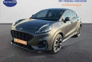 Ford Puma gris foncé vue 3/4 avant droit avec jantes alliage noires et calandre imposante.