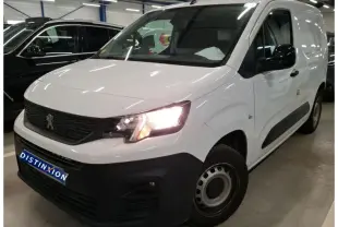 Vue 3/4 avant droit du Peugeot Partner Fourgon blanc 2022 avec phares allumés et pare-chocs noir mat distinctif.