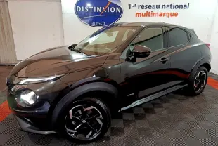 Nissan Juke Hybrid 143 Business+ noir vu de 3/4 avant droit, avec jantes noires et logo Distinxion en arrière-plan.