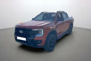 Ford Ranger Wildtrak orange Ignite vu en 3/4 avant droit avec jantes noires et barres de toit.