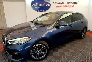 BMW Série 1 118i Edition Sport bleu vue 3/4 avant droit, avec phares LED et jantes alliage noires.