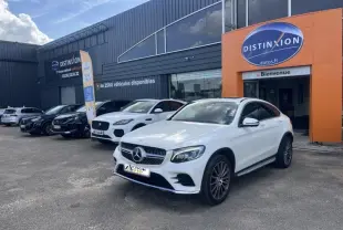 Mercedes GLC Coupé blanc diamant brillant designo, vue 3/4 avant droit devant un concessionnaire Distinxion.