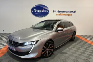 Peugeot 508 SW gris Platinium en 3/4 avant droit, avec toit ouvrant et jantes noires bicolores.