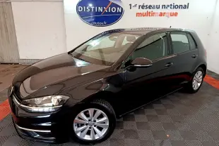 Volkswagen Golf noire vue en 3/4 avant droit, avec jantes argentées et phares allumés.