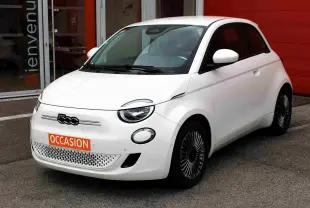 Fiat 500 électrique blanche vue 3/4 avant droit, avec jantes stylisées et plaque "OCCASION" orange visible.