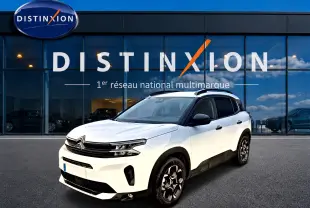 Citroën C5 Aircross blanc vue 3/4 avant droit avec jantes alu et barres de toit noires devant showroom Distinxion.