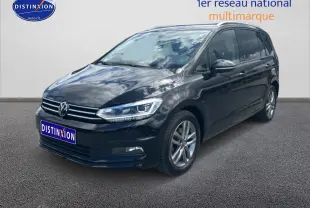 Volkswagen Touran noir vu en 3/4 avant droit, avec calandre chromée et jantes alliage visibles.