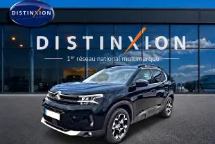 Citroën C5 Aircross noir vue 3/4 avant droit, avec jantes alu et barres de toit visibles devant un showroom Distinxion.
