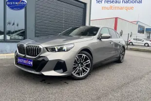 BMW Série 5 (G60) 520da gris vue 3/4 avant droit avec jantes alu et calandre imposante.