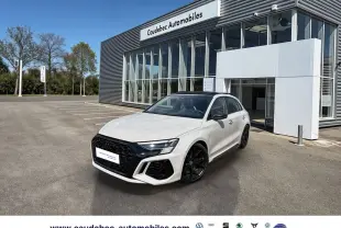 Audi RS3 Sportback gris vue 3/4 avant droit, calandre noire et jantes noires mat devant concession.