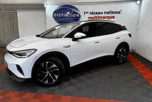 Volkswagen ID.4 blanc en 3/4 avant droit, avec jantes noires et toit panoramique dans un showroom.