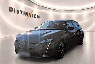 Peugeot 308 gris selenium vue 3/4 avant droit, avec calandre distinctive et feux LED verticaux allumés.
