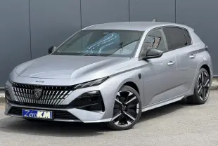 Peugeot 308 gris Artense vue 3/4 avant, avec calandre noire distinctive et jantes alliage bi-ton.