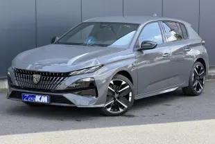 Peugeot 308 NV Hybrid gris Selenium en 3/4 avant droit, avec jantes alliage bi-tons et calandre distinctive.