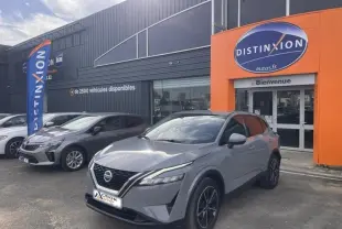 Nissan Qashqai 1.3 Mild Hybrid gris argile avec toit noir, vue 3/4 avant droit devant un concessionnaire Distinxion.