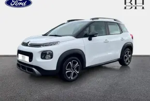 Citroën C3 Aircross blanc Natural White vue 3/4 avant droit avec barres de toit et jantes noires distinctives.
