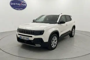 Jeep Avenger blanc en 3/4 avant droit, avec calandre noire distinctive et jantes argentées, sur fond neutre intérieur.