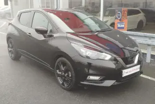 Nissan Micra 2022 noir obscur vue 3/4 avant droit avec jantes noires et phares LED allumés.