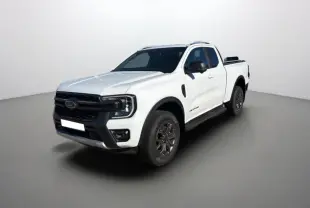 Ford Ranger 2.0 205 Wildtrak blanc pur en 3/4 avant droit avec barres de toit et jantes noires.