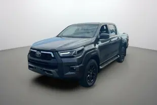 Toyota Hilux 4x4 gris atlas en 3/4 avant droit, avec calandre noire et jantes alliage sombres, version Invincible 2025.