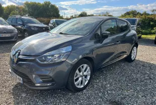 Vue avant d'une Renault Clio IV gris métallisé 2019 avec plaques françaises, garée sur un sol gravillonné.