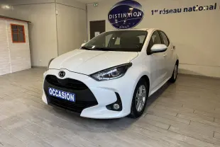 Vue 3/4 avant droite d'une Mazda2 blanche 2023 hybride essence en showroom avec plaque "OCCASION" visible.