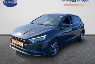 Hyundai i20 gris Aurora métal vue 3/4 avant droit avec jantes alliage et calandre noire distinctive.