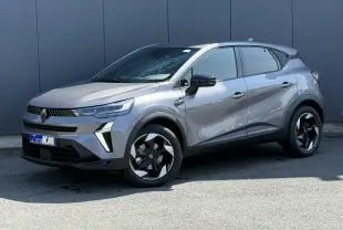 Renault Captur 2026 gris Cassiopée en 3/4 avant droit, avec jantes noires et détails modernes sur carrosserie.