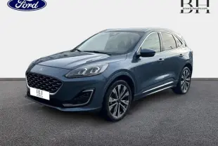 Ford Kuga 2023 bleu azur métallisé en vue 3/4 avant, avec jantes alliage 20 pouces et toit panoramique électrique.