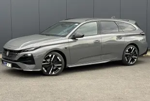 Peugeot 308 SW gris Sélénium en vue 3/4 avant droit, avec jantes alliage bi-tons et barres de toit noires.