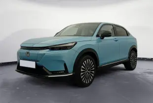 Honda e:Ny1 204 ch Advance bleu électrique, vue 3/4 avant droit mettant en valeur ses jantes stylisées et son design moderne.