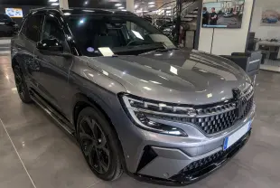 Renault Austral E-Tech hybride gris schiste avec toit noir, vue 3/4 avant droit en intérieur showroom.